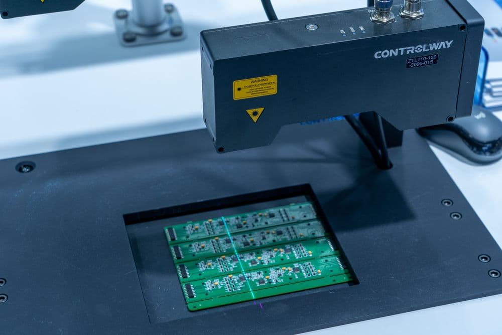 Circuit boards passing under an automated inspection scanner.