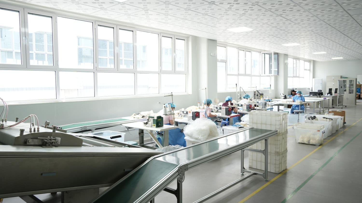 A bright, orderly production room with workers at their stations.